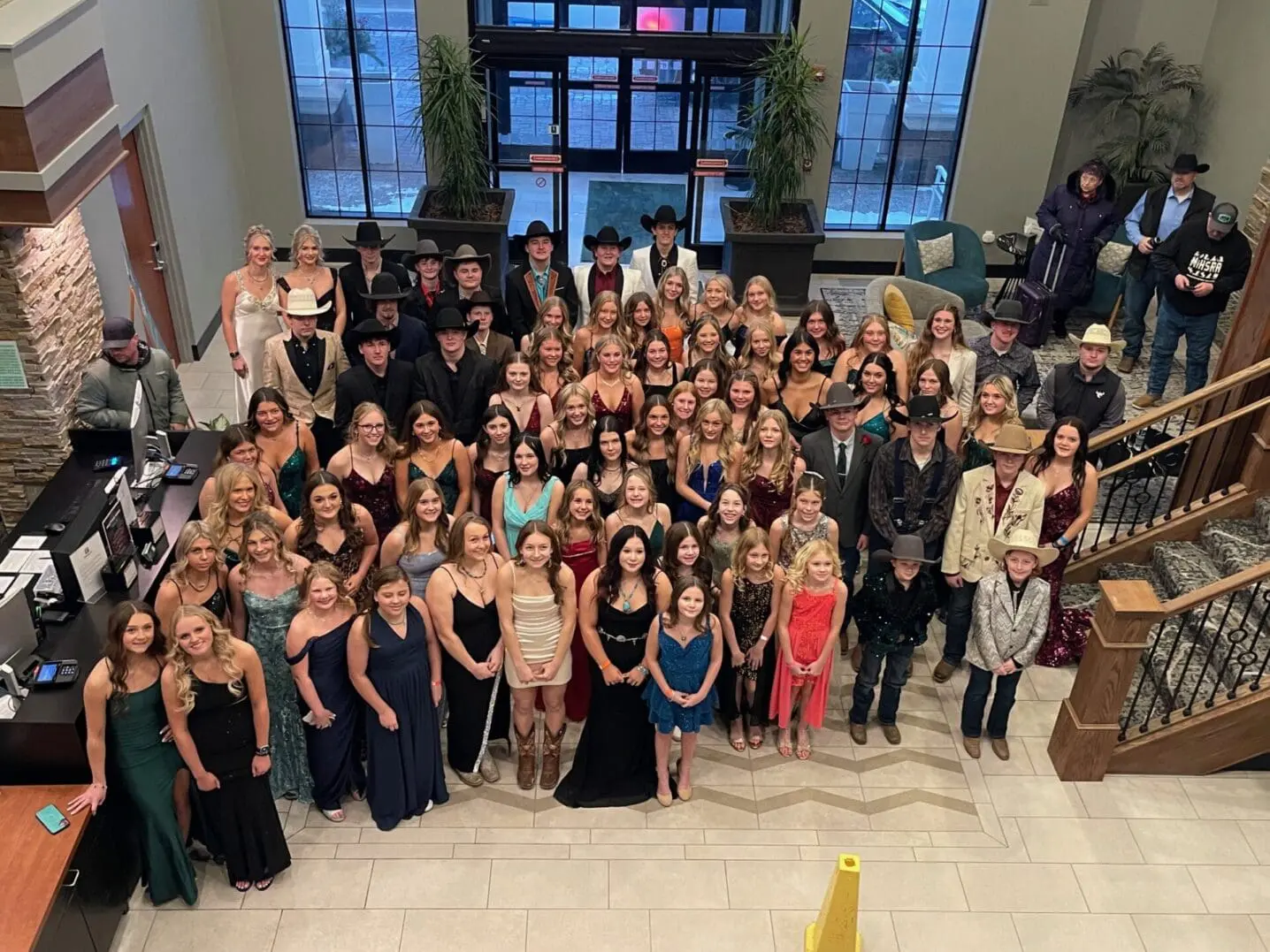 Large group in formal attire posing in lobby